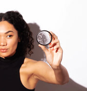 A person smiling and showing a Flex Menstrual Disc