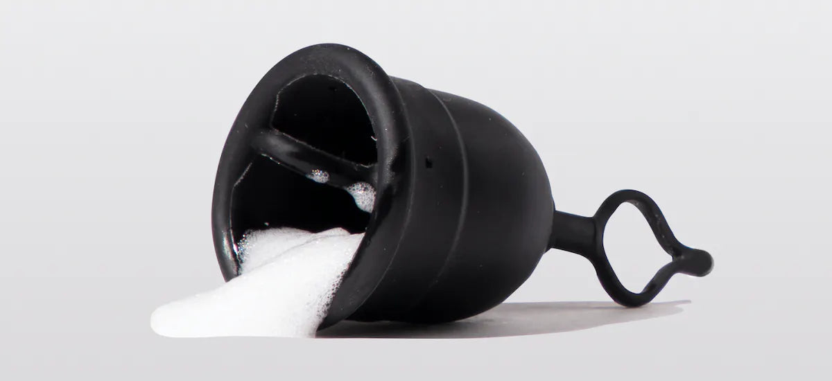 Menstrual cup with ring stem filled with soap suds